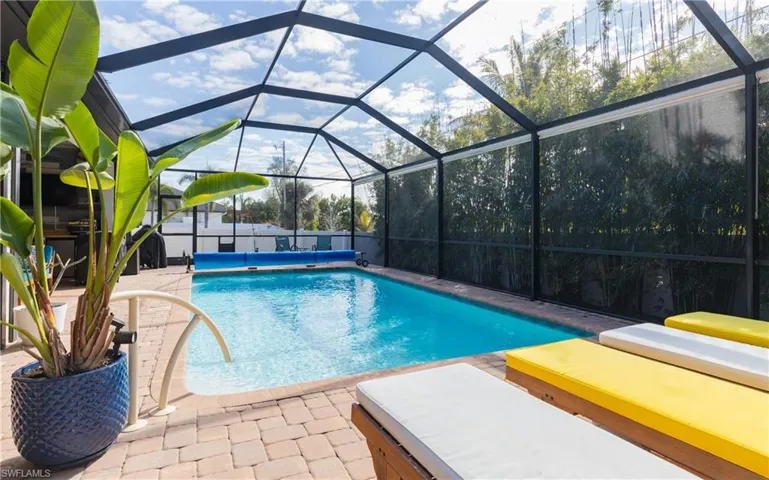 View of swimming pool with a lanai, a sunroom, patio surround, and a jacuzzi
