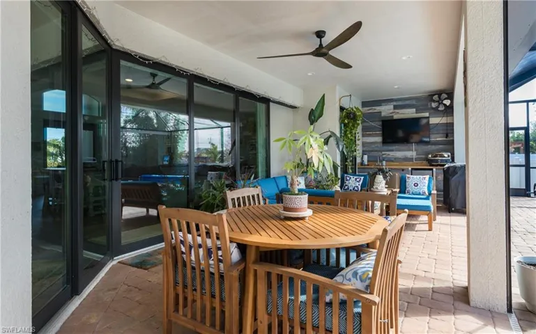 Sunroom / solarium with a patio area, a ceiling fan, and outdoor dining area