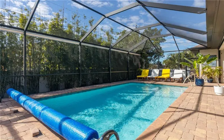 View of swimming pool featuring a lanai, a covered pool, patio surround, and a sunroom