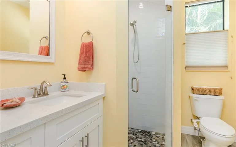Full bathroom with vanity and a shower stall