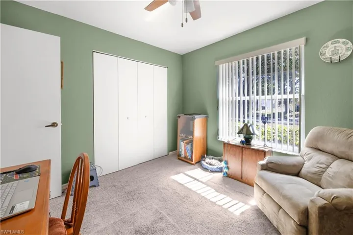 Living area with a ceiling fan and carpet