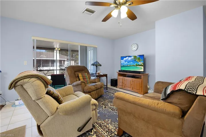 Living area featuring a ceiling fan and tile patterned floors