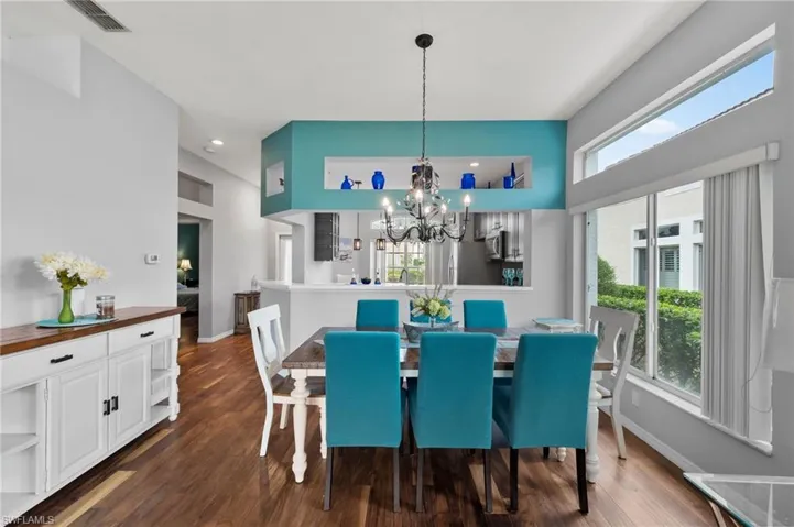 Dining space featuring a notable chandelier, dark hardwood / wood-style flooring, and plenty of natural light