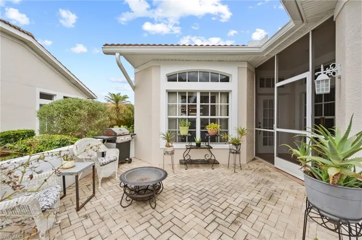 View of patio with an outdoor fire pit and a sunroom