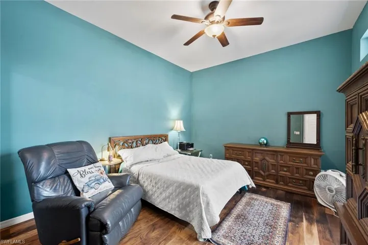 Bedroom with dark hardwood / wood-style flooring and ceiling fan