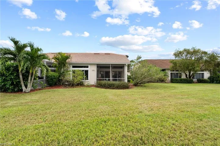 Back of house with a yard and a sunroom