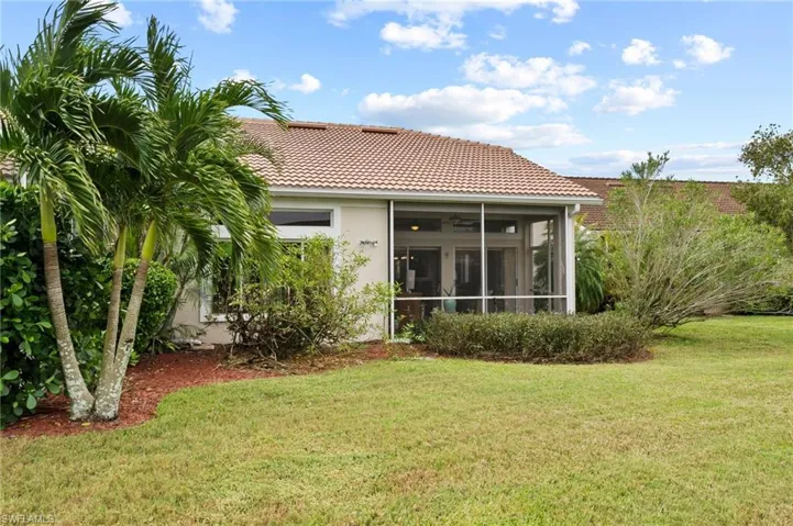Back of house featuring a yard and a sunroom