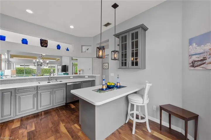 Kitchen with sink, dishwasher, kitchen peninsula, and gray cabinetry