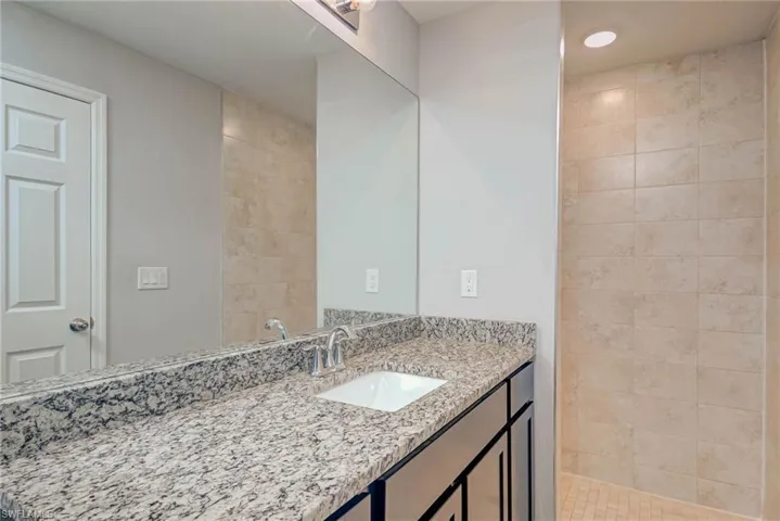 Full bathroom featuring a tile shower and vanity