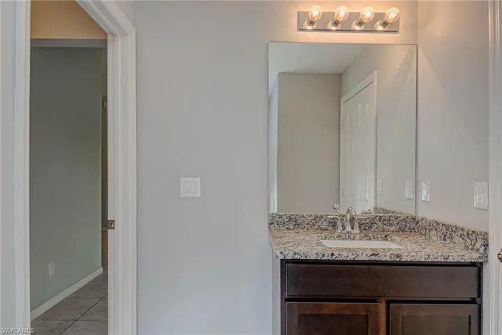 Bathroom featuring tile patterned floors, baseboards, and vanity