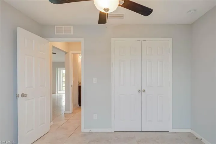 Unfurnished bedroom featuring visible vents, baseboards, a closet, and light tile patterned flooring