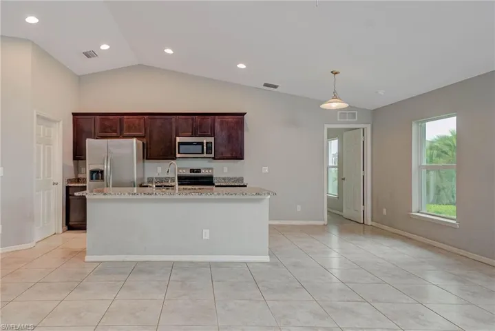 Kitchen featuring stainless steel appliances, visible vents, and a kitchen island with sink