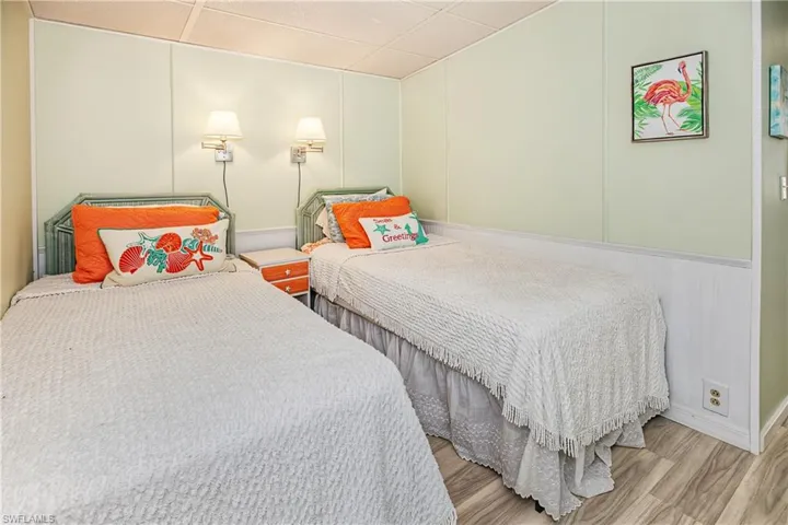 Wood-finish flooring with light-toned wall panels and a white chair rail
