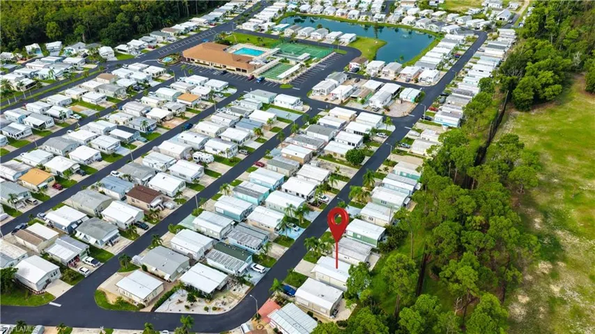 Community setting with multiple residential structures, paved roads, and mature trees