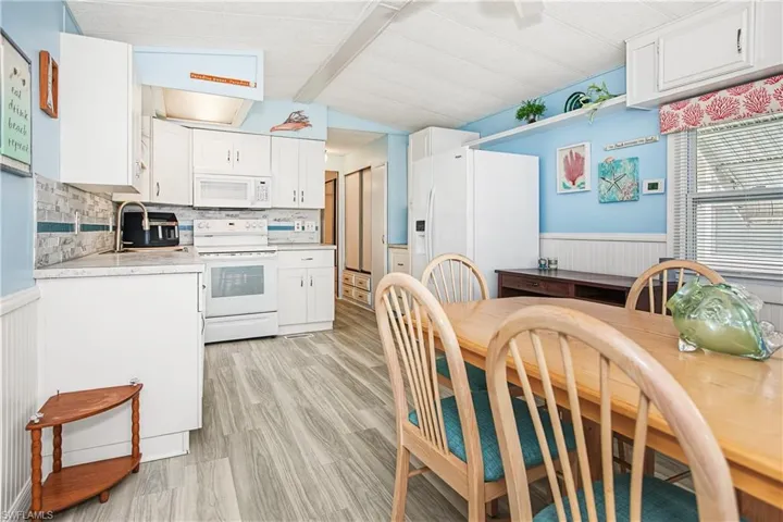 White cabinetry with a tile backsplash and light-toned countertops