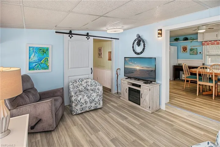 Wood-finish flooring throughout, with a white barn door on a black track