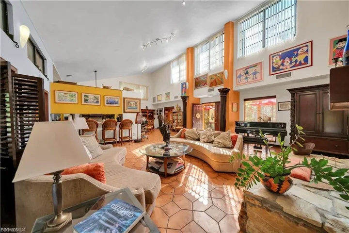 Vaulted ceilings with high windows, decorative columns, and hexagonal tile flooring