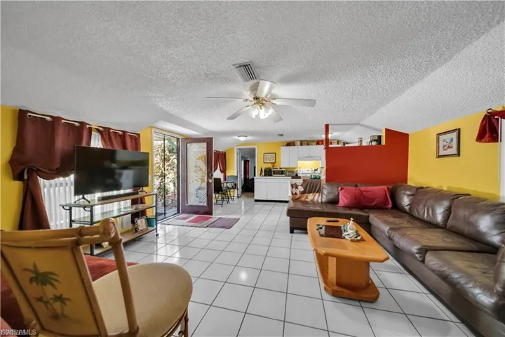 Ceramic tile flooring throughout, ceiling fan with light fixture, and sliding glass door