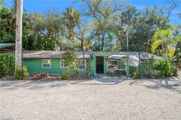 Single-story residence with a green exterior, white-framed windows, and a covered porch