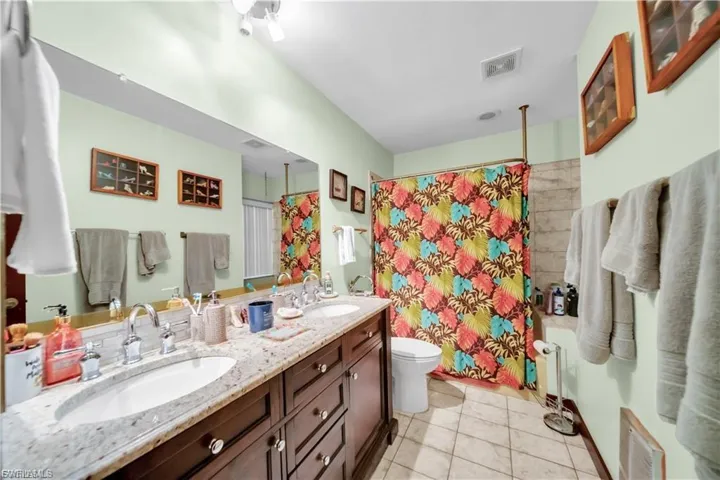 Dual vanity with integrated sinks, granite-style countertop, and wood-finish cabinetry