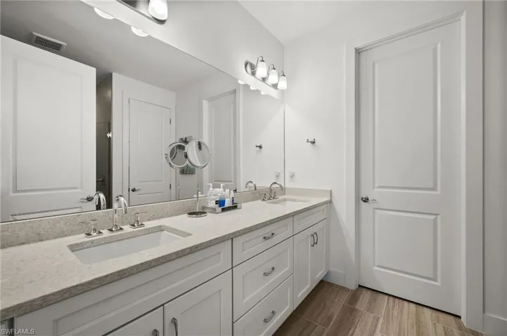 Bathroom featuring wood finished floors, double vanity, a sink,