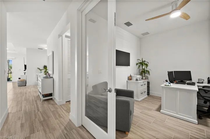 Office space with light wood-style floors, ceiling fan, baseboards