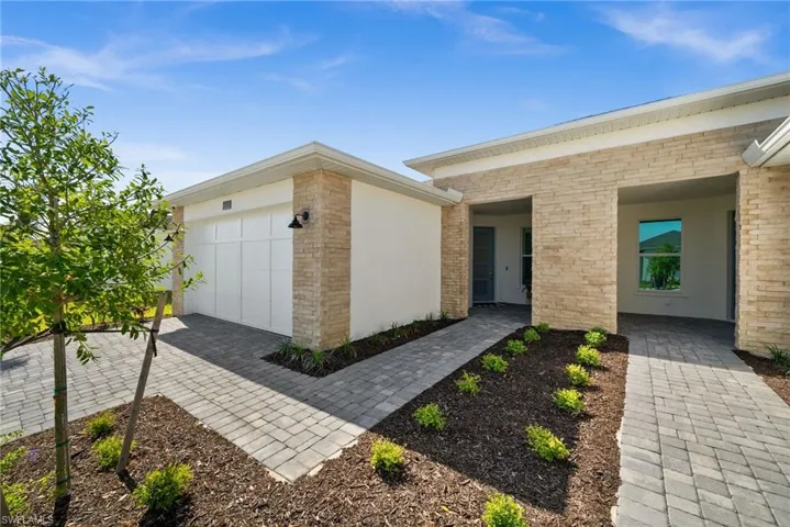 Property entrance featuring a garage and brick siding