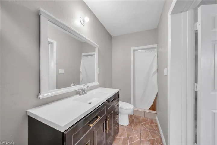 Bathroom featuring a dark wood-finish vanity with a white countertop and integrated dual sinks