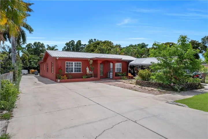 Red exterior residence with a metal roof and white-framed windows