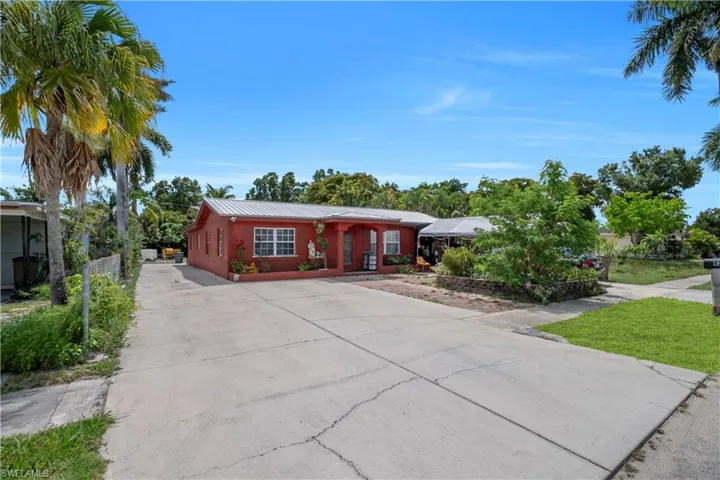 Red-hued exterior featuring a metal roof and a covered entry