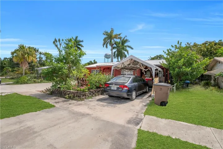 Red-toned exterior with white trim windows and a covered carport