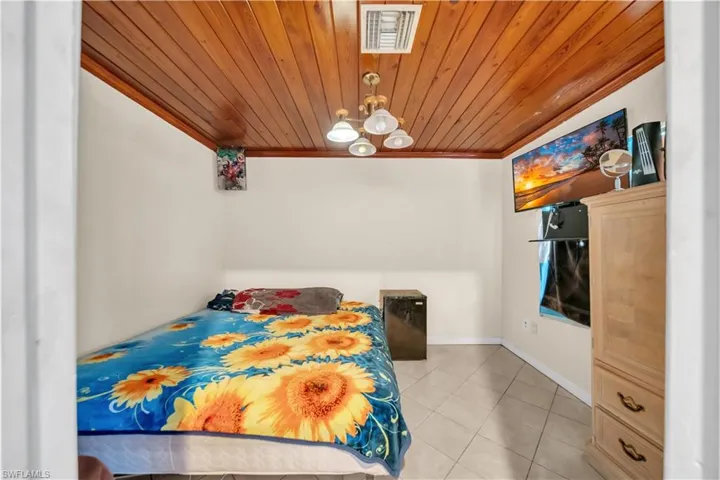 Wood-paneled ceiling with a central multi-bulb light fixture