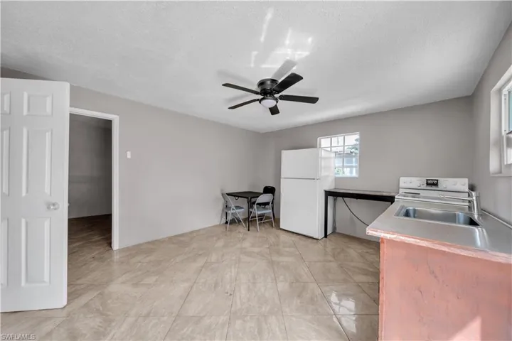 Interior space featuring tile flooring and a ceiling fan with integrated lighting