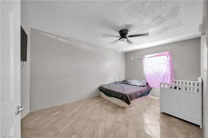 Spacious room featuring neutral wall tones and tile flooring