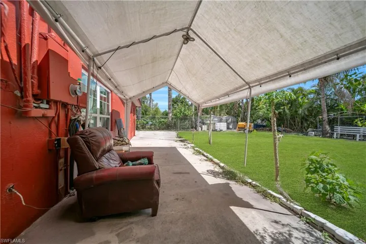 Covered patio area featuring a concrete slab, white tent structure, and string lighting