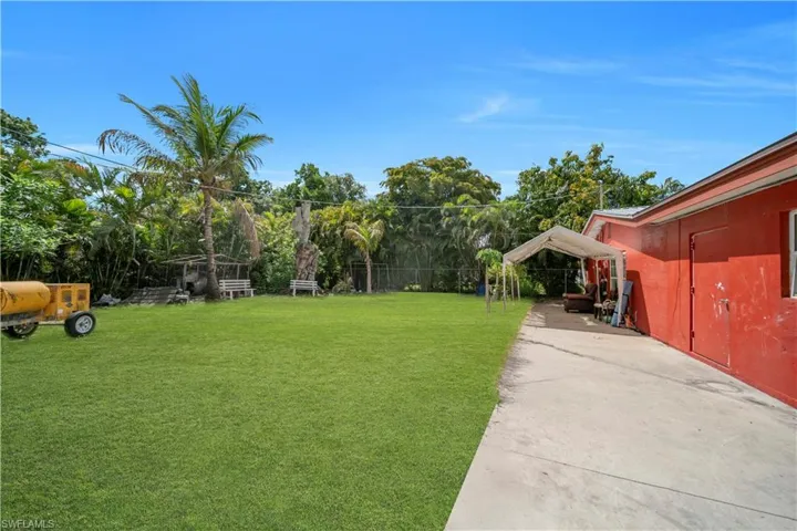 Expansive green lawn with mature tropical foliage