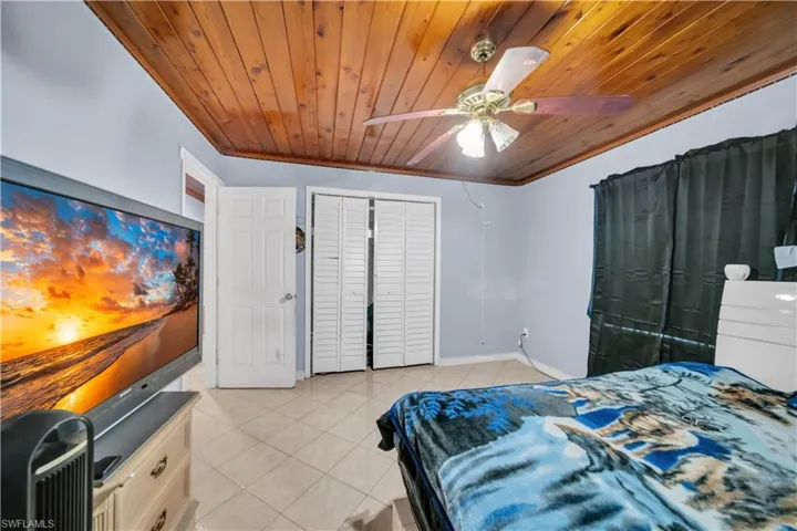 Room with a wood-panel ceiling and a ceiling fan