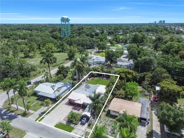 Aerial property overview featuring a red-sided structure with a light-colored roof