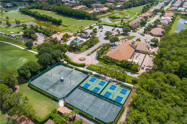 Aerial view of property and surrounding area featuring a nearby body of water and a golf club