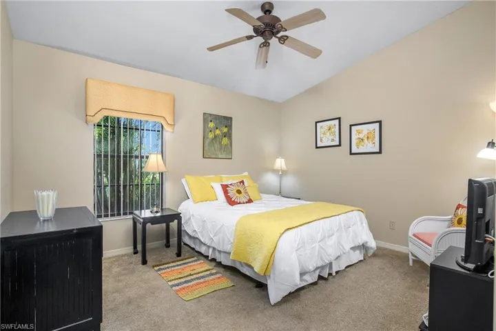 Bedroom with carpet flooring, baseboards, lofted ceiling, and a ceiling fan