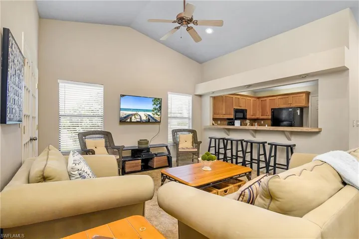 Living room with a ceiling fan and high vaulted ceiling