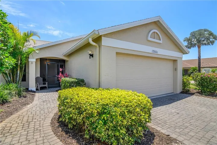 View of front of home featuring stucco siding, an attached garage, and driveway