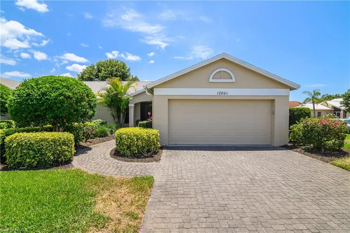 View of front of home featuring stucco siding, decorative driveway, and an attached garage