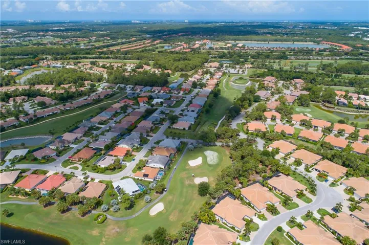 View of property location with nearby suburban area, a nearby body of water, and a golf club