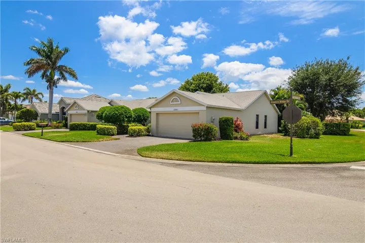View of front of house featuring a garage, driveway, a front lawn, stucco siding, and a residential view