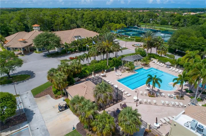 Drone / aerial view of a pool and a heavily wooded area