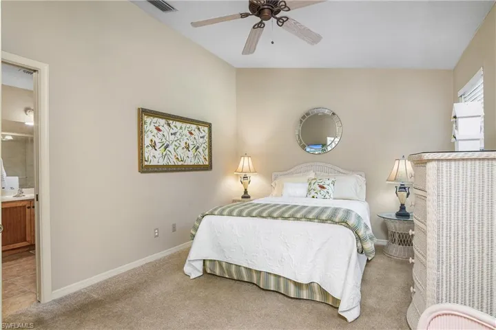 Bedroom with carpet flooring, ensuite bath, baseboards, and ceiling fan