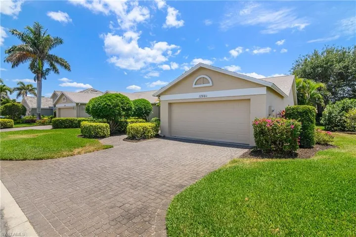 View of front of home with stucco siding, an attached garage, decorative driveway, and a front yard