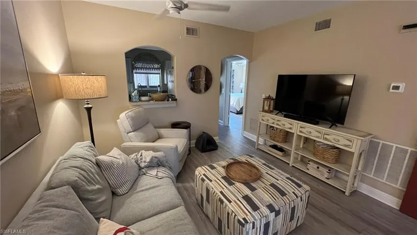 Living room with hardwood / wood-style flooring and ceiling fan