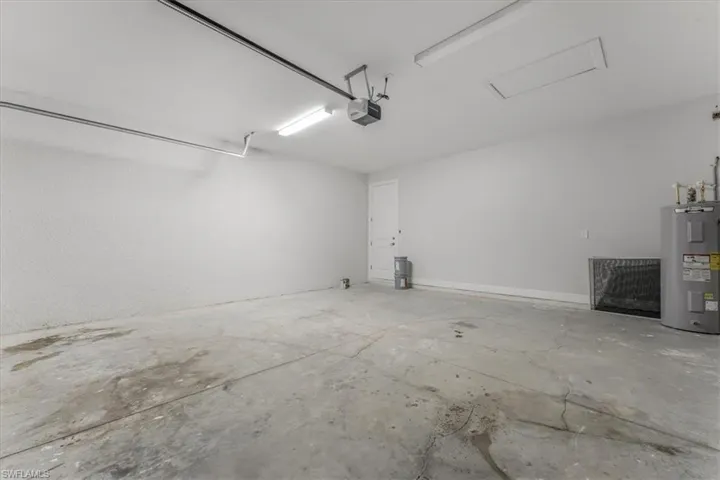 Garage featuring water heater and a garage door opener